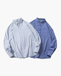 Two oversized striped button-down shirts, one pale blue and white, one royal blue and white, laid flat