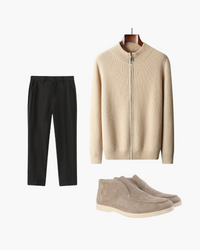 Cream ribbed zip-up jumper, black trousers and taupe suede desert boots, flat-lay outfit set