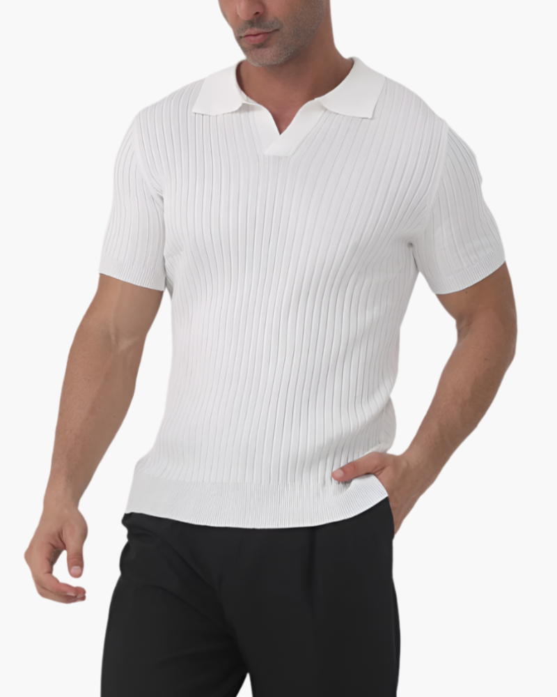 Man wearing white ribbed short-sleeve polo with open collar, hand in pocket, black trousers