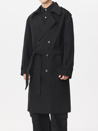 Homme en trench croisé noir à ceinture et épaulettes, vue de face avec pantalon noir