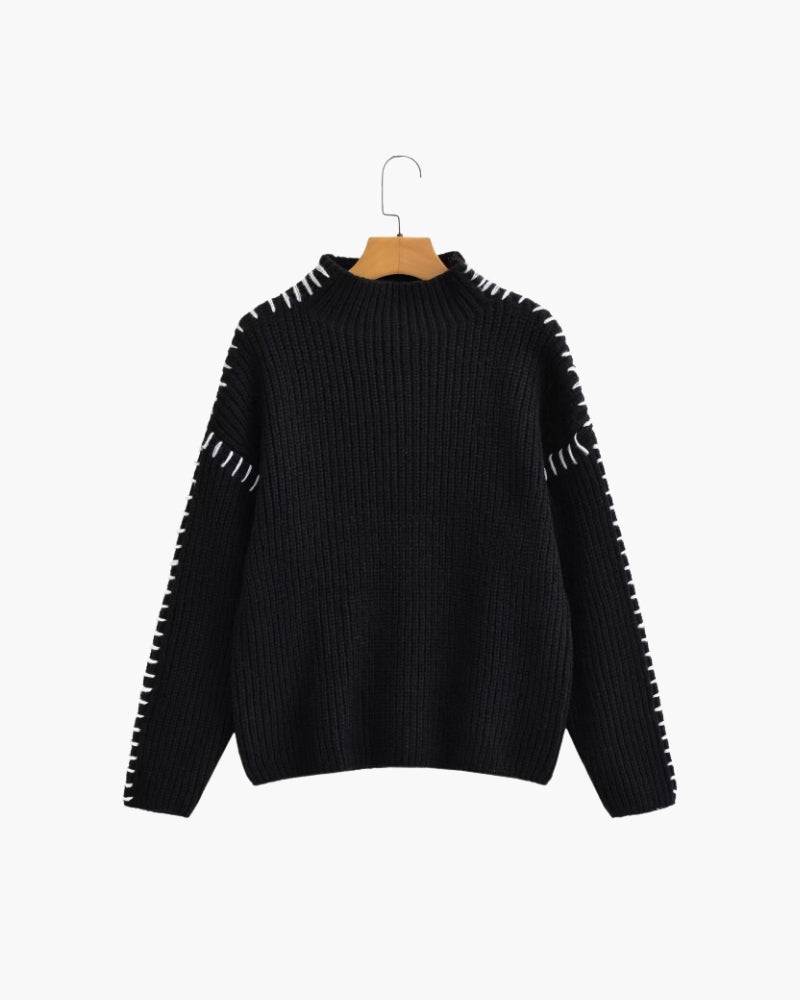 Black oversized jumper with white whipstitch seams and funnel neck, on a hanger, front view