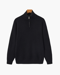 Black ribbed knit half-zip pullover with stand collar and drop shoulders, front view on a wooden hanger