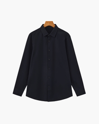 Navy long-sleeve shirt with pointed collar and dark buttons on a wooden hanger, flat front view