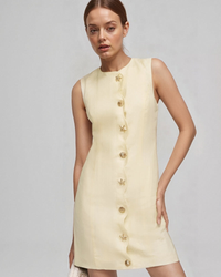 Pale yellow sleeveless mini dress with a wavy button placket, worn by a model, front view
