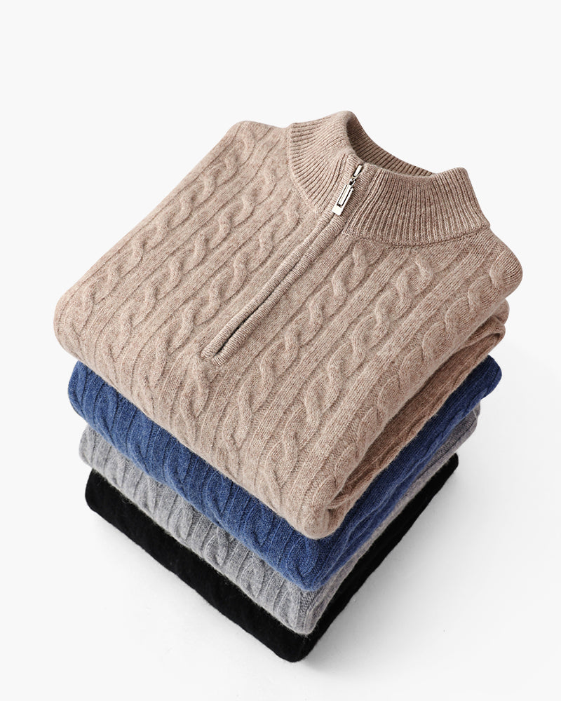 Folded stack of cable-knit cashmere half-zip jumpers in beige, blue, grey and black