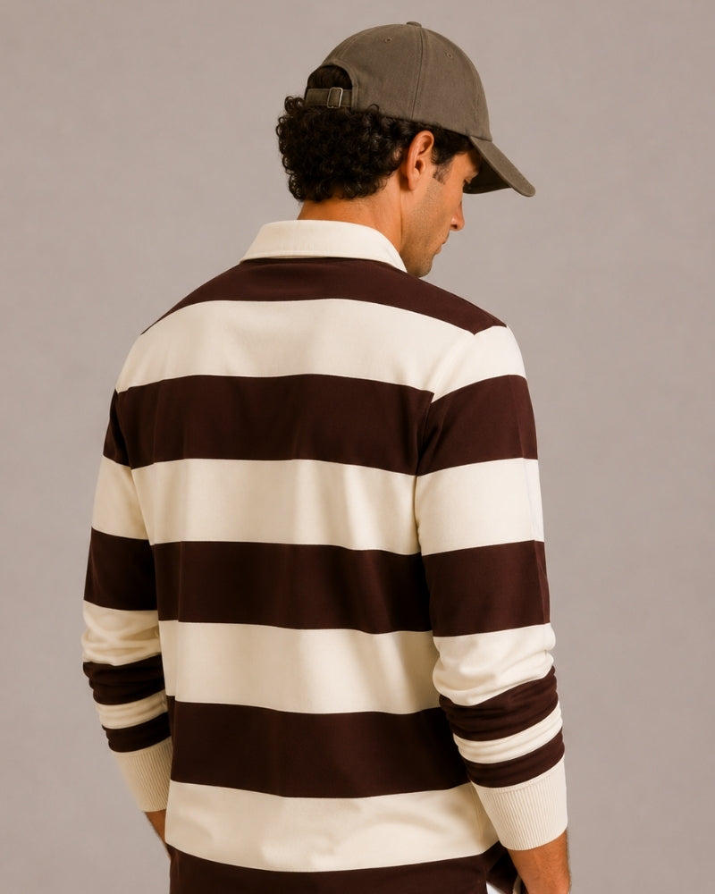 Hombre con polo de rugby a rayas marrón y crudo y gorra verde oliva, vista trasera