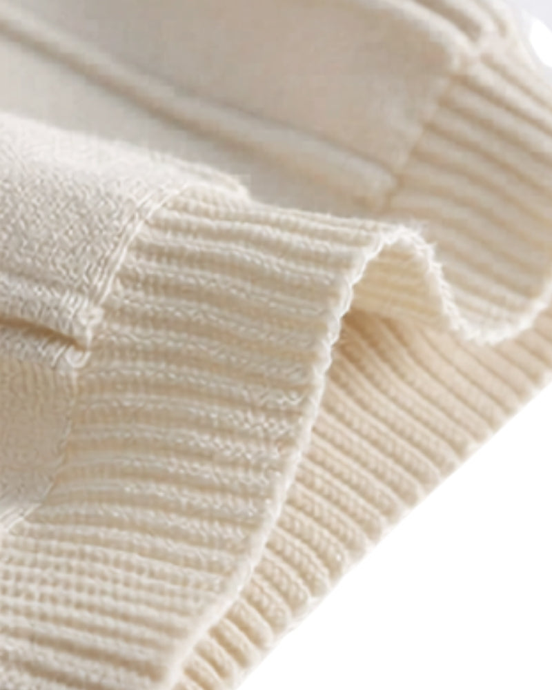 Close-up of cream ribbed knit sleeve cuff and fabric fold on the polo