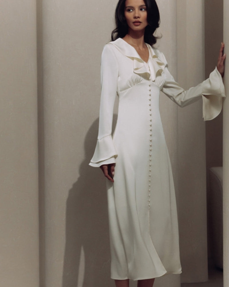 Woman in ivory satin-look midi dress with ruffle V-neck, pearl buttons and tiered bell cuffs