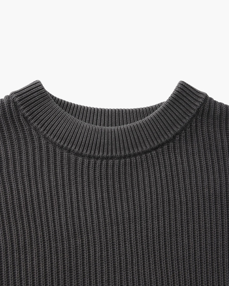 Close-up of charcoal-grey rib-knit jumper ribbed crew neckline, flat-lay on white