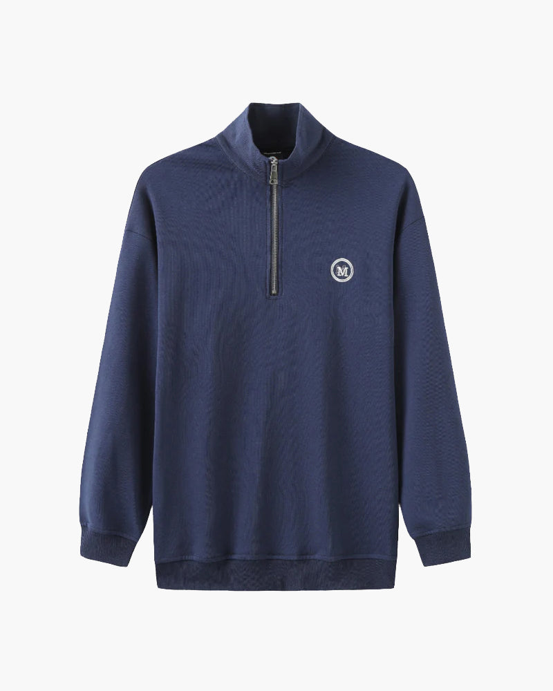 Navy half-zip sweatshirt with stand collar, round M logo and ribbed cuffs, flat-lay front view