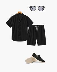 Ensemble chemise texturée noire à col cubain et short à cordon, avec lunettes de soleil et mocassins noirs, à plat