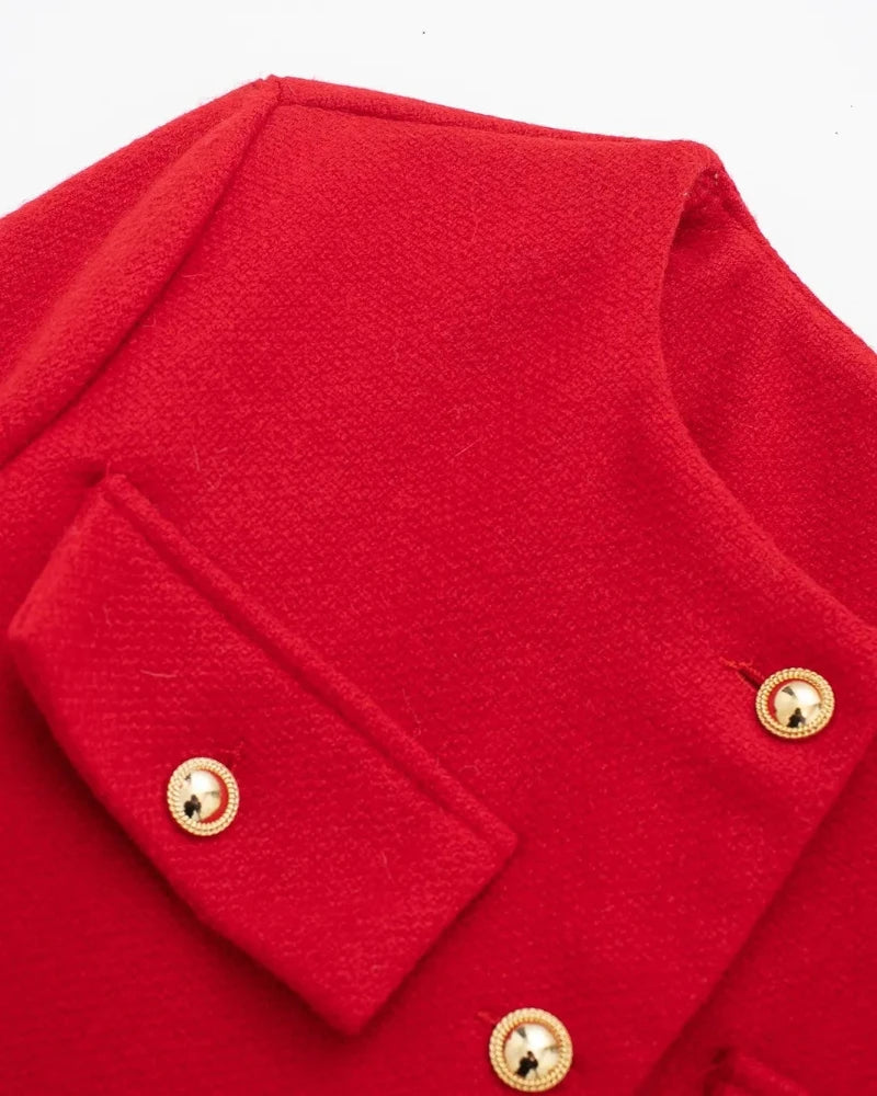 Close-up of red tweed jacket flap pocket and round gold buttons showing the woven texture