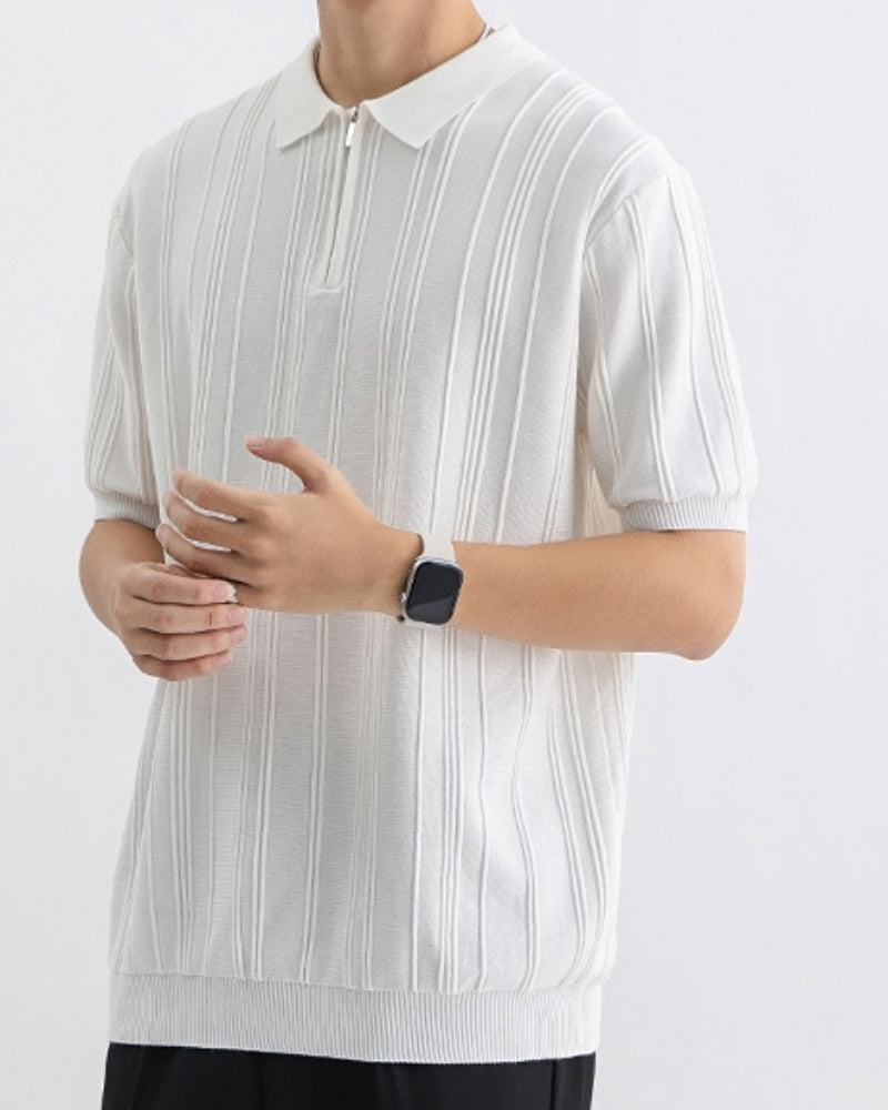 White vertical-ribbed knit zip polo, worn with a smartwatch and black trousers, front view