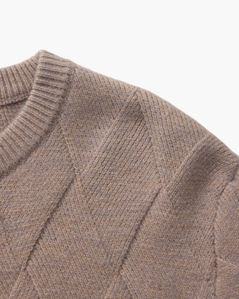 Gros plan sur l'épaule et l'encolure côtelée d'un pull moka-taupe en maille losange