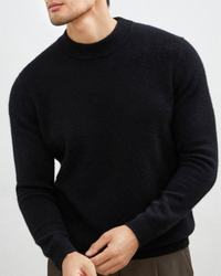 Man in a black slim-fit cashmere-wool jumper with a ribbed neckband, close crop of torso