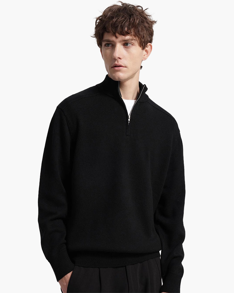 Hombre con jersey de lana merino negro con media cremallera y camiseta blanca en el cuello, vista frontal