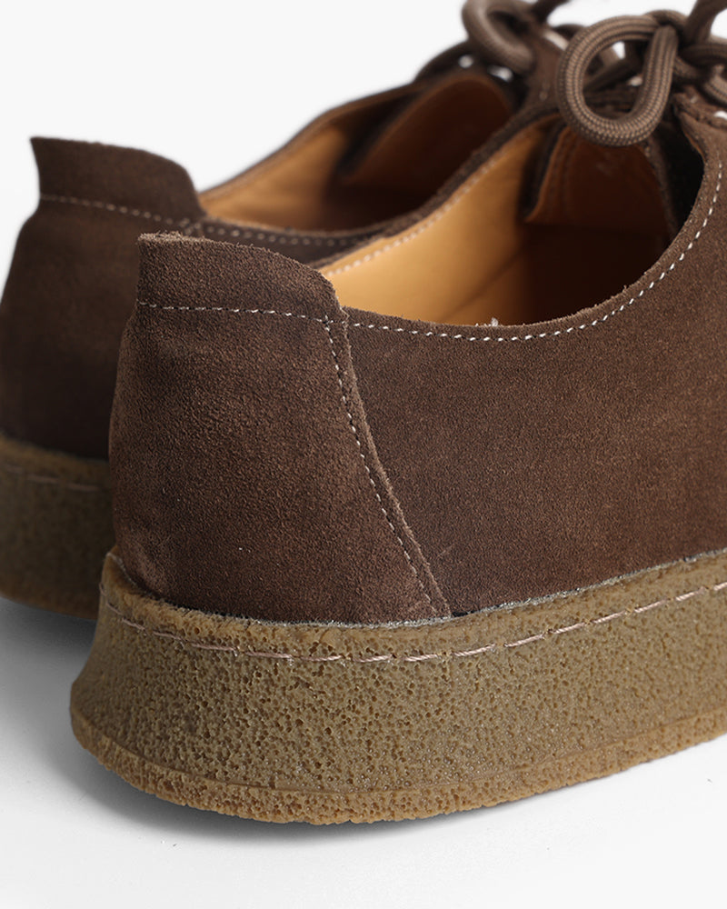 Close-up of dark brown suede shoe heel and gum crepe sole with contrast stitching