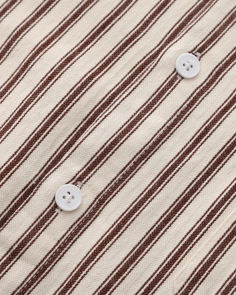 Detail of white buttons on brown and cream striped shirt placket