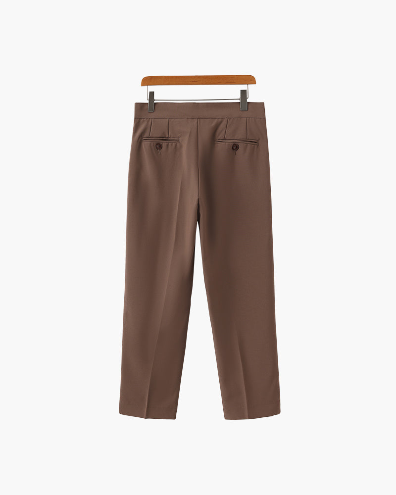 Back view of brown pleated trousers with two button-through back pockets, on a wooden hanger
