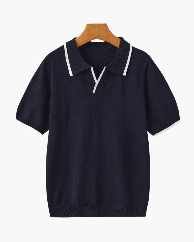 Navy knit polo with white-tipped open collar, V placket and cuffs on a wooden hanger, front view