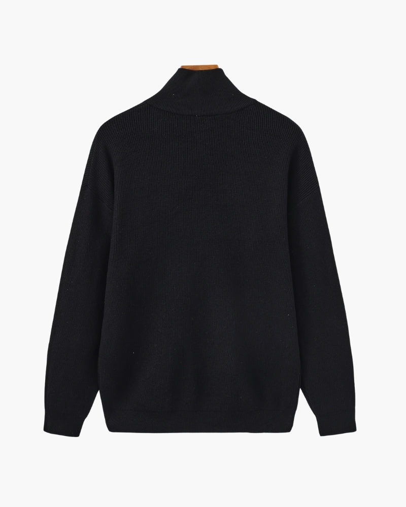 Back view of black ribbed knit half-zip pullover with stand collar, on a wooden hanger