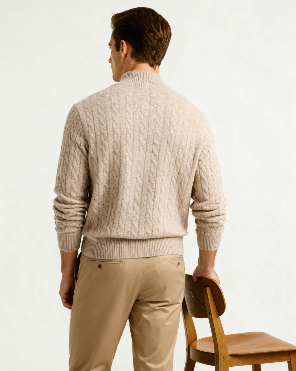Back view of a beige cable-knit cashmere half-zip jumper with khaki trousers, on model