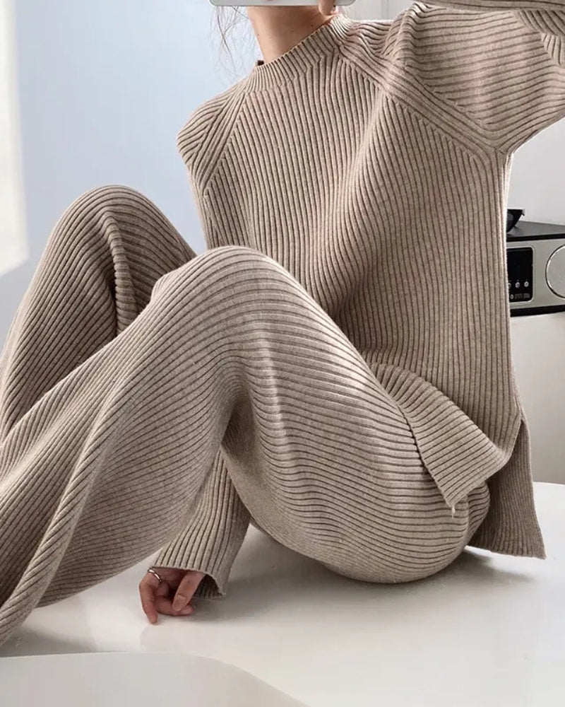 Woman seated in a beige ribbed knit jumper and wide-leg trousers, close crop of the knit