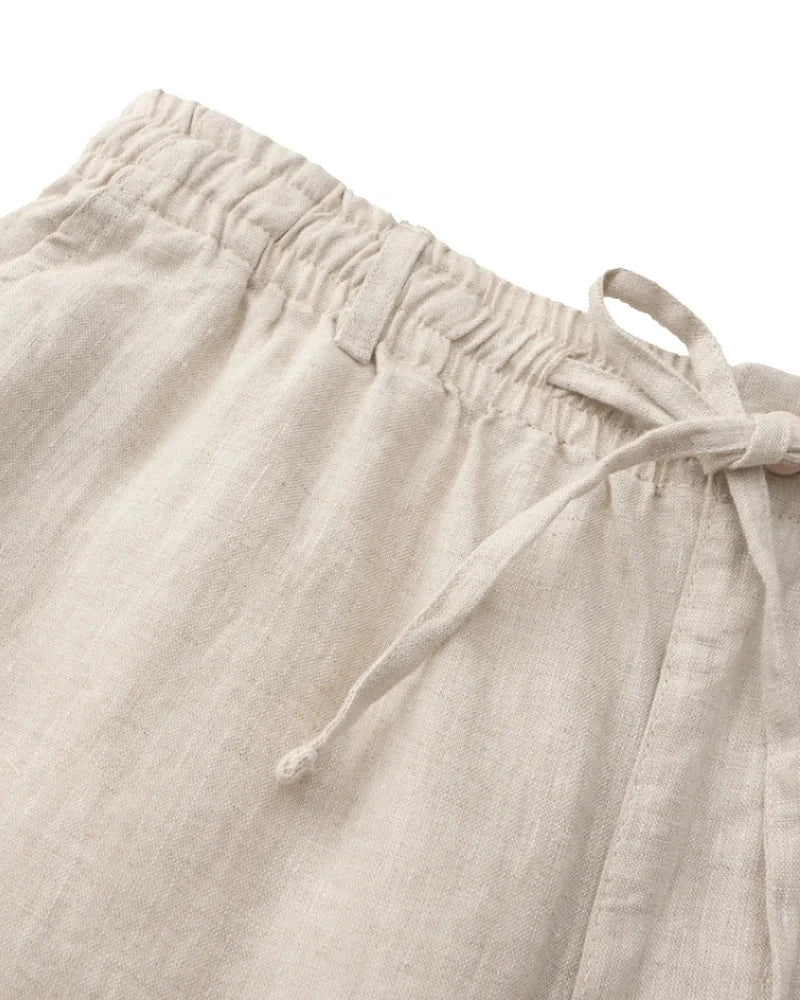 Close-up of natural linen shorts elastic waistband and drawstring with knotted end