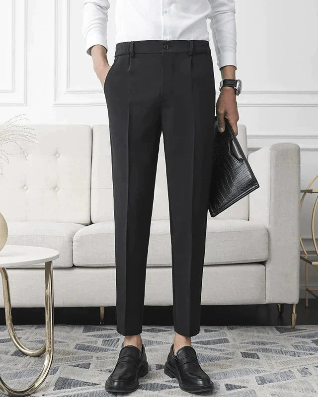 Black tapered trousers worn with a white shirt, black loafers and a croc-effect clutch