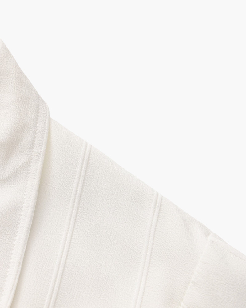 Close-up of white ribbed shirt shoulder seam and chest pocket edge
