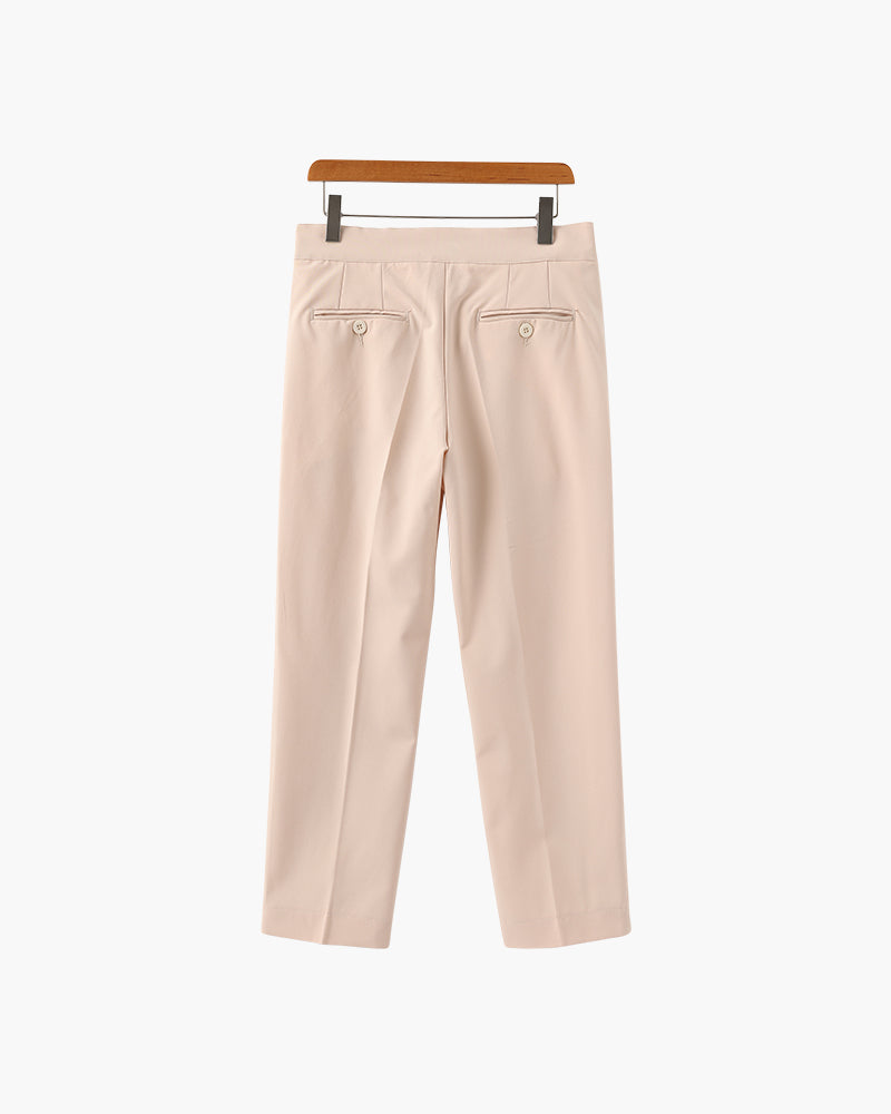 Back view of beige-pink pleated trousers with two button-through back pockets, on a wooden hanger