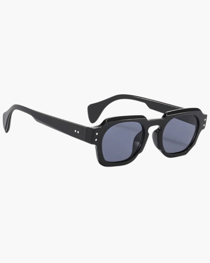 Chunky angular black acetate sunglasses with grey-tinted lenses and rivets, three-quarter view