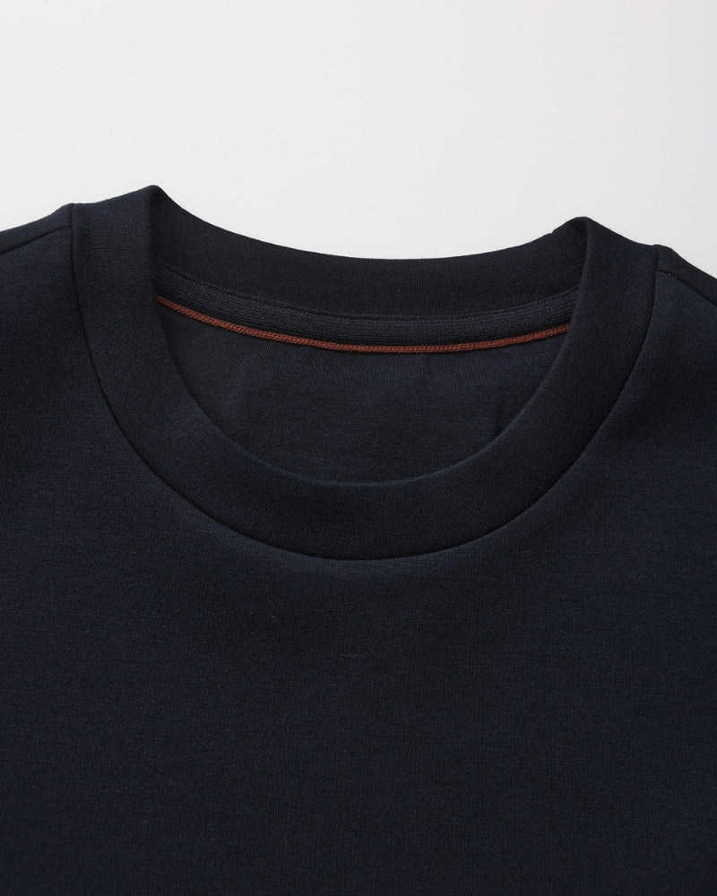 Gros plan sur l'encolure ronde d'un sweat bleu marine avec ruban intérieur camel