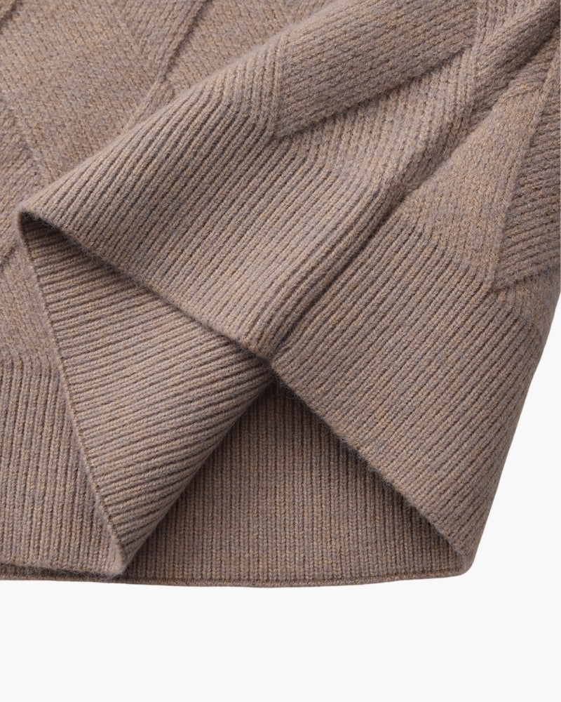 Gros plan sur l'ourlet et la fente latérale d'un pull moka-taupe vus d'en bas