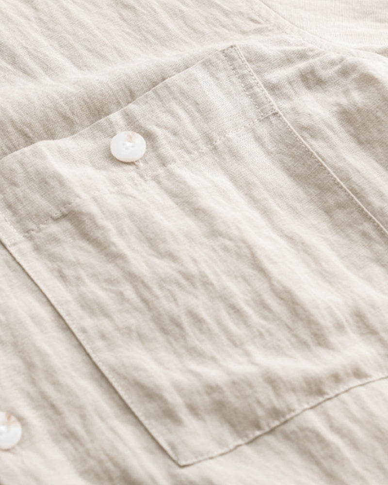 Close-up of beige linen overshirt chest pocket with shell button