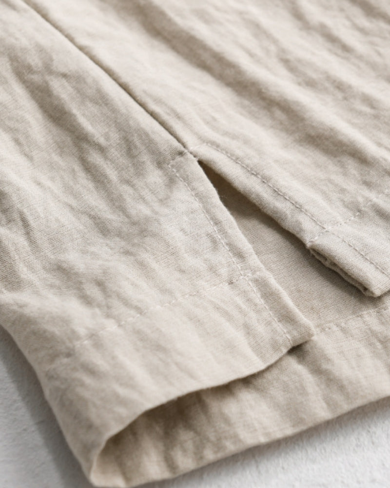 Close-up of beige linen overshirt side-slit hem with topstitching