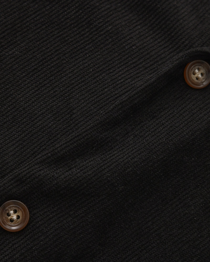 Close-up of black textured shirt fabric with horn-effect buttons