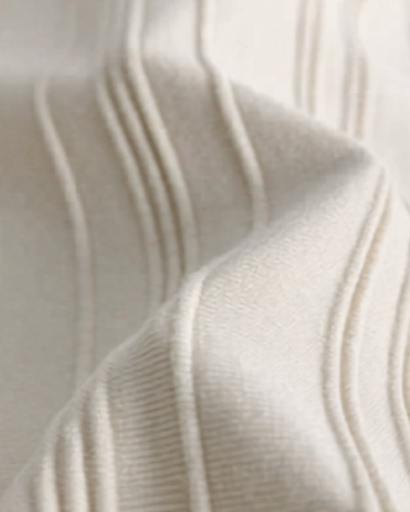 Close-up of cream vertical-ribbed knit fabric with raised stripes on the polo