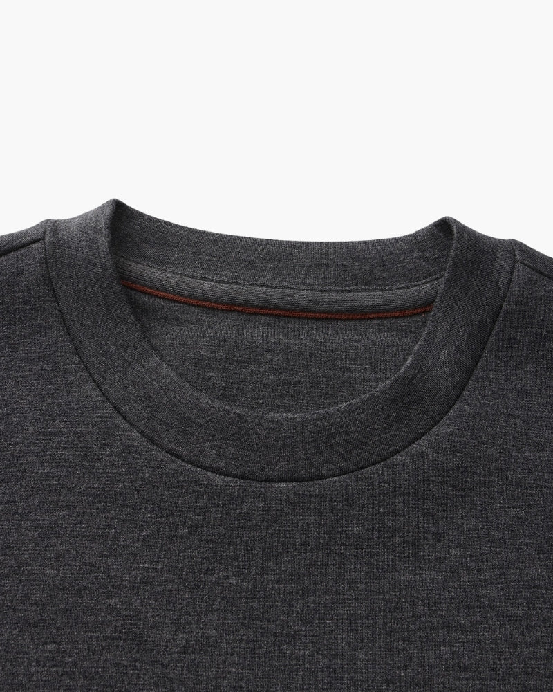 Gros plan sur l'encolure ronde d'un sweat anthracite avec ruban intérieur couleur rouille