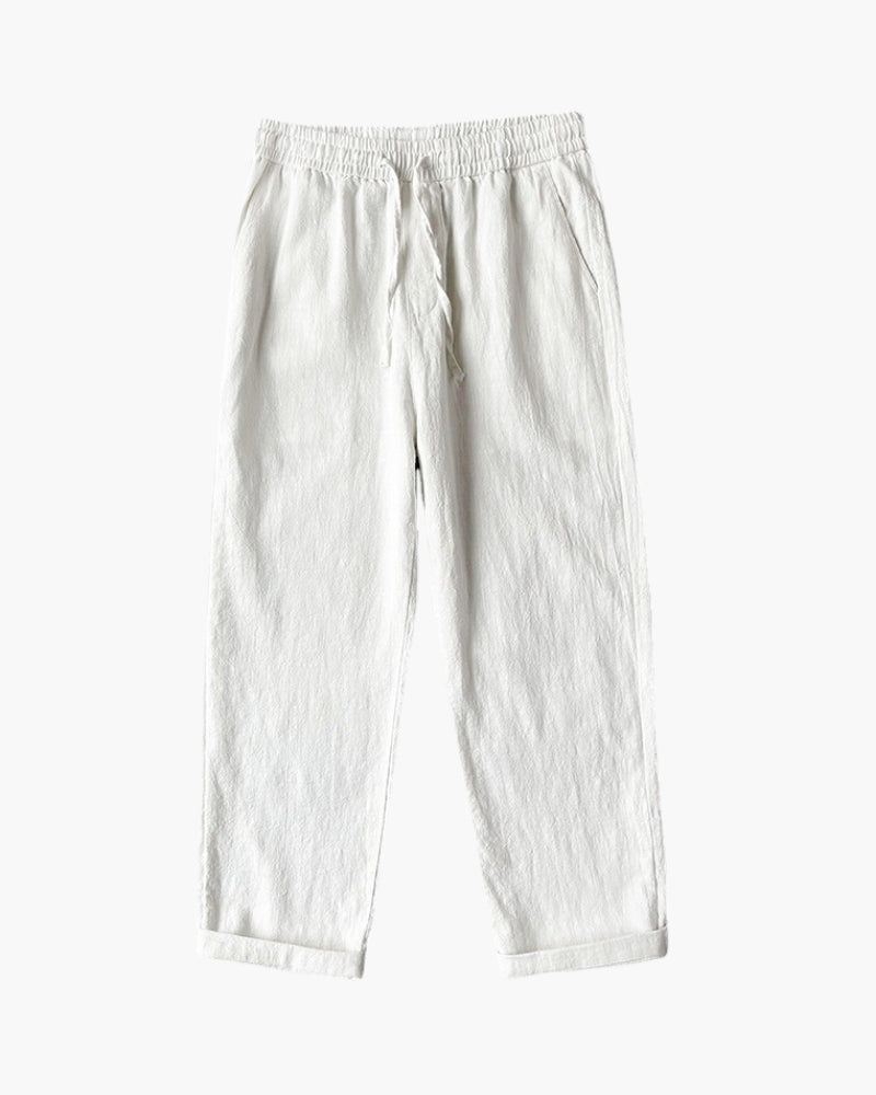 White linen drawstring trousers with elastic waist and rolled hems, flat-lay front view