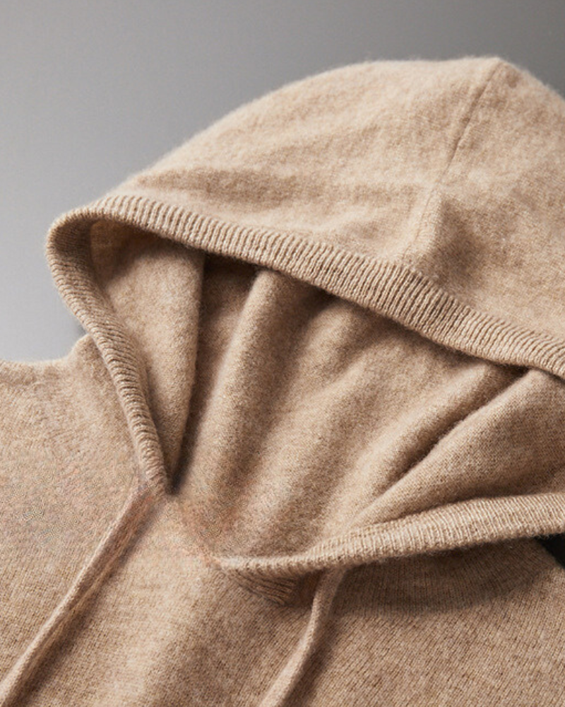 Close-up of a camel-beige cashmere hood with ribbed edge and drawstring, soft brushed knit