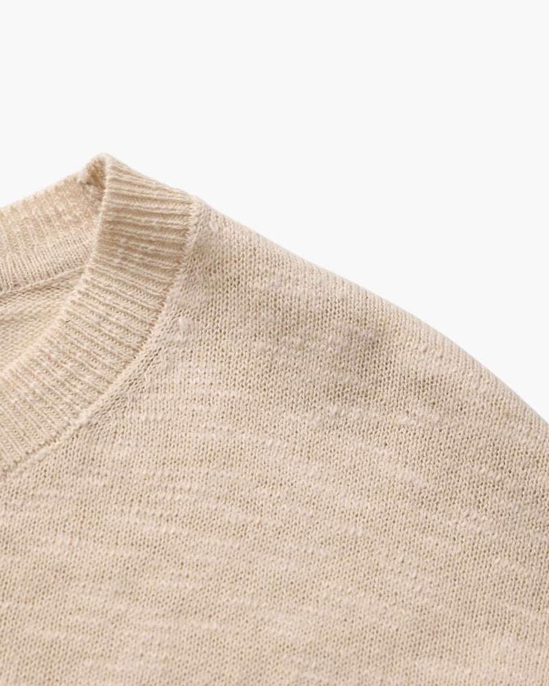 Gros plan sur la couture d'épaule et le col côtelé d'un tee-shirt col rond beige – Tee-shirt col rond à manches longues en lin-coton