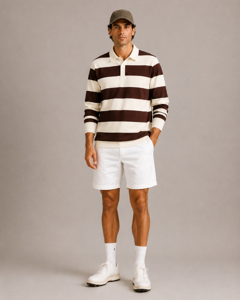 Hombre con polo de rugby a rayas marrón y crudo, shorts blancos y zapatillas, vista frontal de cuerpo entero