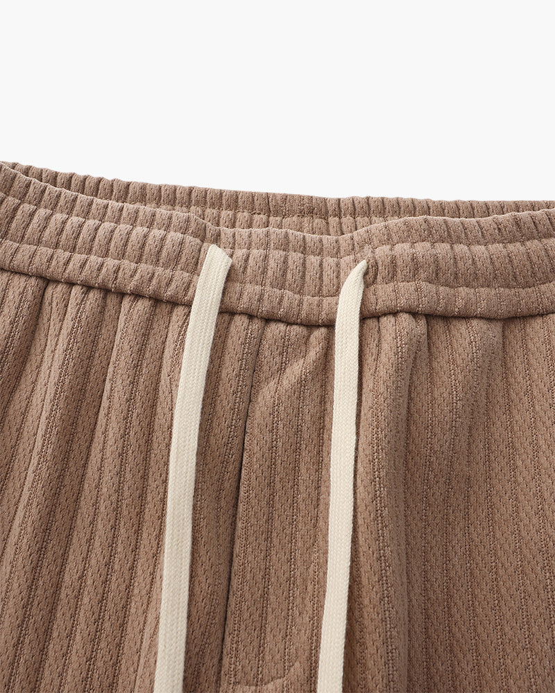 Close-up of taupe-brown ribbed velvet trousers elastic waistband and cream drawstring cord