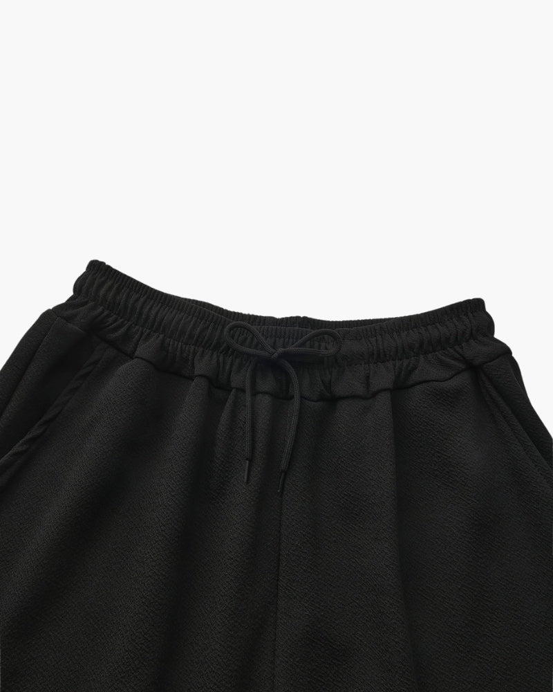 Close-up of a black elasticated waistband with drawstring and side pocket