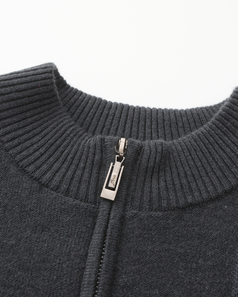 Close-up of a charcoal cashmere half-zip collar with metal zip pull and ribbed neckband