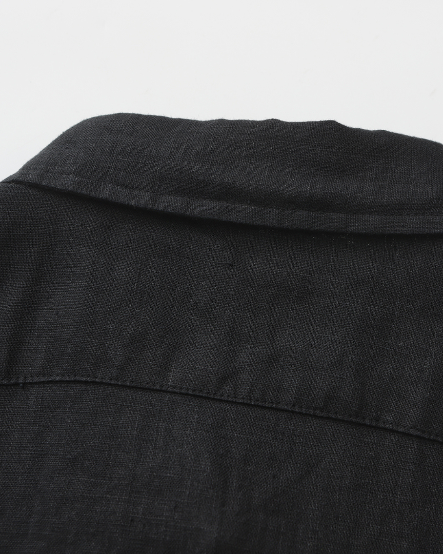 Close-up of black linen shirt collar and back yoke seam showing the woven texture