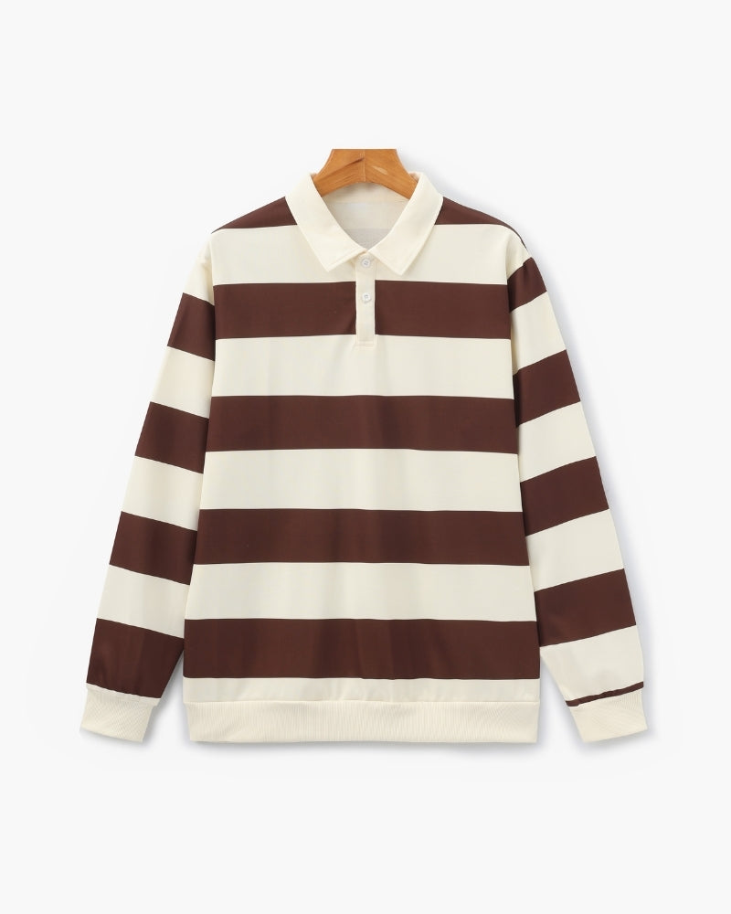 Polo de rugby de rayas anchas marrón y crudo en una percha de madera, en plano vista frontal con bajo de canalé