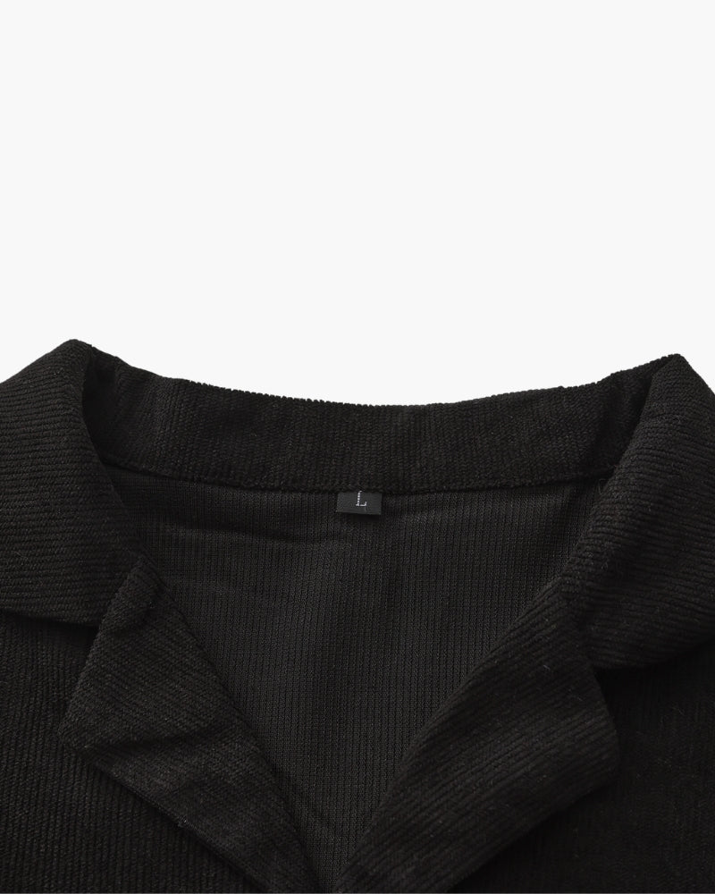 Close-up of black textured camp collar with size label inside the neck, detail shot