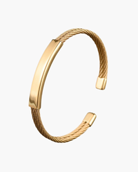 Gold-tone open cuff bracelet with twisted cable sides and flat engravable plate, flat-lay
